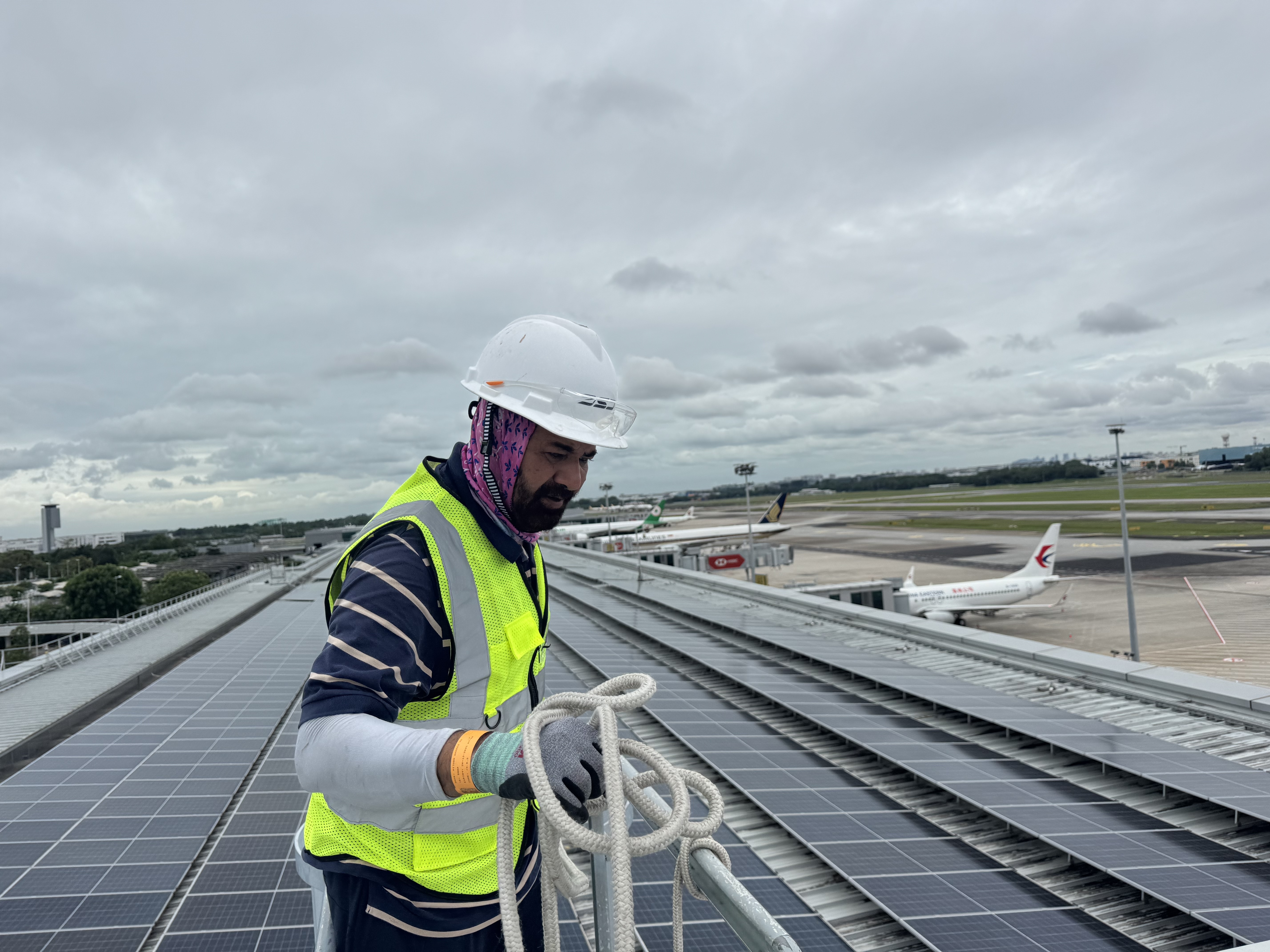 JSJ worker on Changi Airport T3 roof with planes in background